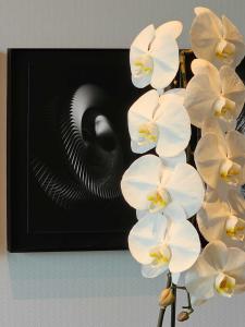 a bunch of white orchid flowers in front of a picture at Kamo Residences by Reflections in Kyoto