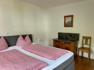 a bedroom with a bed and a vanity and a mirror at Haus Widmann in Scheffau am Wilden Kaiser +18 photos