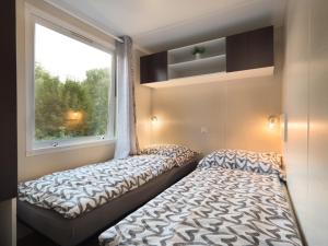 Duas camas num pequeno quarto com uma janela em LAURAHAUS em Děčín