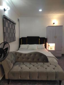 a bedroom with a large bed with a large couch at Kemzie's Apartments in Port Harcourt