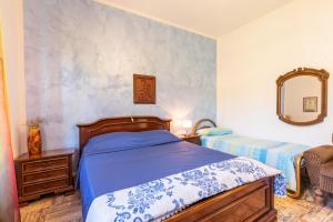 Schlafzimmer mit einem Bett und einem Wandspiegel in der Unterkunft Casa Raffaello in Castiglione dʼOrcia