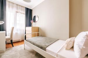 a bedroom with a bed and a chair and a window at Stylish Retreat w Balcony 2 min to Bagdat Ave in Istanbul