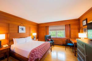 a bedroom with a bed and a desk and a desk at Williamsburg Lodge, Autograph Collection in Williamsburg