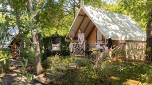 a man and woman standing outside of a small house at Polidor Glamping Resort in Poreč