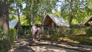 a man and a woman walking in front of a cabin at Polidor Glamping Resort in Poreč
