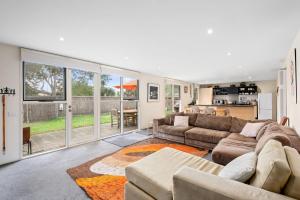 Una sala de estar con dos sofás y una cocina. en Spindrift, en Point Lonsdale