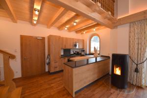 a kitchen with a fireplace in the middle of a room at Krölls Alpenchalet in Krimml