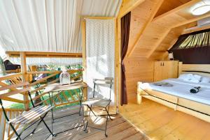 a bedroom with a bed and chairs in a wooden house at Polidor Glamping Resort in Poreč