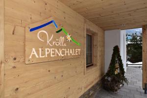 un panneau sur le côté d'un bâtiment en bois dans l'établissement Krölls Alpenchalet, à Krimml
