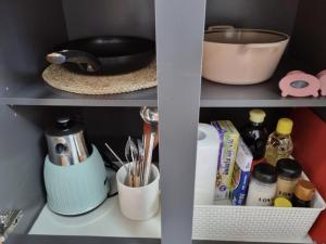 a kitchen shelf with utensils and other kitchen items at DAON STAR BnB j6 in Daegu