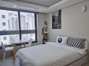 1 dormitorio con cama, mesa y ventana en DAON STAR BnB j6, en Daegu