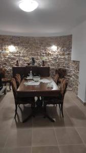 a table and chairs in a room with a stone wall at Ανακαινισμένο Διαμέρισμα in Chios