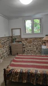 a bedroom with a bed and a stone wall at Ανακαινισμένο Διαμέρισμα in Chios