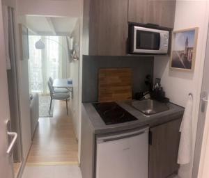 a small kitchen with a sink and a microwave at Chambre indépendante en face de la Gare Lille Flandres in Lille