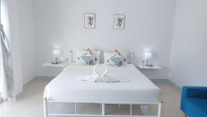 a white room with two beds and a blue couch at Cinderella Residence in Patong Beach