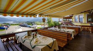 een restaurant met tafels en uitzicht op een parkeerplaats bij Panorama Hotel Gasthof Leidingerhof in Mondsee