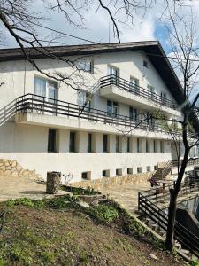 a white building with balconies on the side of it at Хижа Тополица -The beautiful view in Aytos