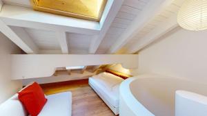 um pequeno quarto no sótão com uma cama e uma banheira em Ers 52 em Pontresina mais 18 fotografias