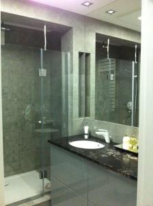 a bathroom with a sink and a glass shower at Apartament Kewin in Gdańsk +14 photos