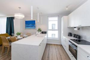 eine Küche mit weißen Schränken und ein Esszimmer in der Unterkunft Villa Neptun - Exclusive Apartments in Danzig