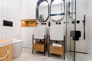 ein Badezimmer mit Toilette und Spiegel in der Unterkunft Villa Neptun - Exclusive Apartments in Danzig