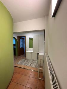 a kitchen with white cabinets and a tile floor at Apartament de lux, zona centrala in Gura Humorului