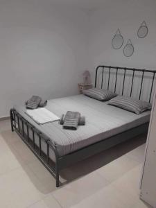 uma cama com duas almofadas num quarto em White and Grey Tinos em Stení