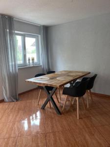 una mesa de madera y sillas en una habitación con ventana en Ferienwohnung 3 Schweizer, 
