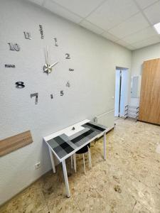 a room with a clock on the wall and a desk at Neuwertiges Apartment mit schnellem WLAN, Glasfaser, Kostenlose Privatparkplatz auch für Transporter geeignet R2 in Freiberg am Neckar