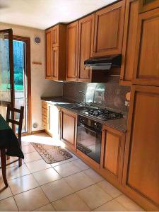 een keuken met houten kasten en een fornuis met oven bij Appartamento di Giulio & Giorgia in Predazzo