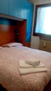 een bed met twee witte handdoeken erop bij Appartamento di Giulio & Giorgia in Predazzo