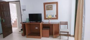 a room with a desk with a television and a chair at AINNY Residence in Patong Beach