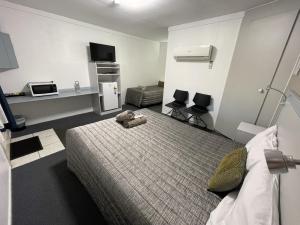 um quarto com uma cama com um urso de peluche em Hatton Vale Motel em Hatton Vale