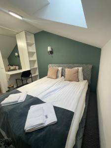 a bedroom with a large bed with towels on it at Apple Economy Hotel in Kaunas