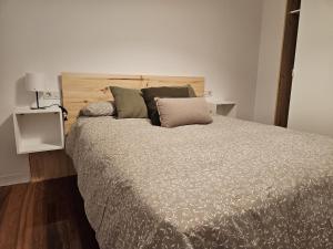 um quarto com uma cama grande com almofadas em C12A01 Coqueto apartamento con piscina y garaje em Suances