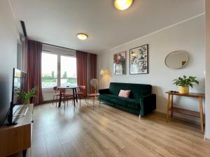 a living room with a green couch and a table at Momo Apartamenty Kręta in Wrocław