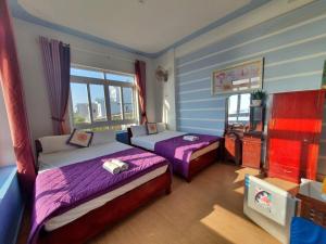 a bedroom with two beds and a television in it at Thanh Tran Guesthouse Lý Sơn in Ly Son