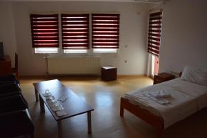 - un salon avec un lit et une table basse dans l'établissement Arabella Hotel, à Kičevo