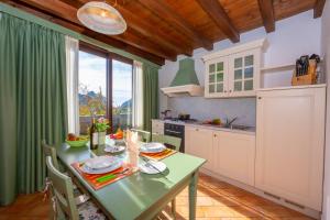 a kitchen with a table and a green table and chairs at Mimosa in Hilly area - Happy Rentals in Gargnano