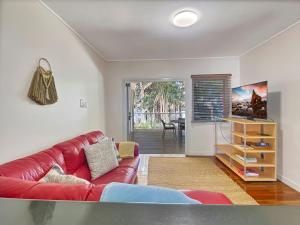 sala de estar con sofá rojo y mesa en Picnic Bay Apartments Unit 3, en Picnic Bay