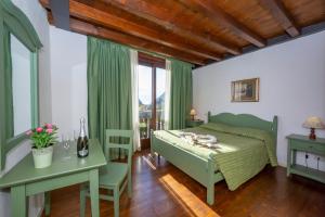 a bedroom with a green bed and a table and a desk at Mimosa in Hilly area - Happy Rentals in Gargnano