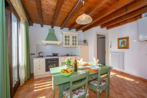 a kitchen with a green table and chairs in a room at Mimosa in Hilly area - Happy Rentals in Gargnano