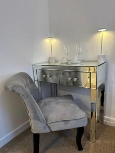 einen Schreibtisch mit einem Stuhl neben einem Schreibtisch mit zwei Lampen in der Unterkunft The smaller new refurbished room 5 min from beach/parking in Guests house. in Bournemouth