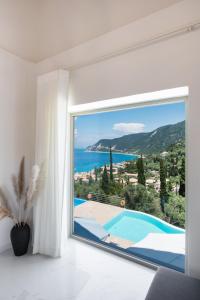 a room with a large window with a view of the ocean at Mylos Mountain Villas- Villa Giorgio in Agios Nikitas