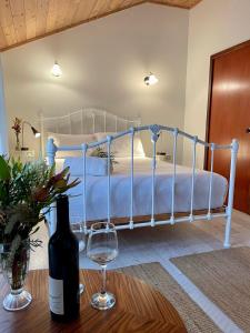 um quarto com uma cama e uma garrafa de vinho numa mesa em Sienna Lodge em Yallingup