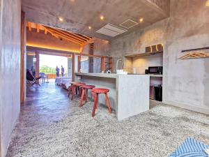 a kitchen with a counter and stools in a room at Amami 与庵 in Amami