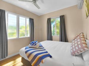 - une chambre avec un lit et 2 serviettes dans l'établissement Picnic Bay Apartments Unit 4, à Picnic Bay