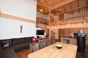 Krölls Alpenchalet في كريمل: غرفة معيشة وغرفة طعام مع أريكة وطاولة