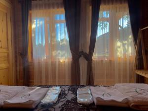 KORU AURA MENGEN في مِنغِن: غرفة نوم بسريرين ونافذة بها ستائر