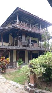 a large wooden building with balconies on it at Rumah Jepun in Mataram